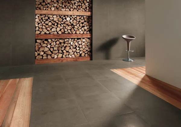 Großformatige Fliesen mit Holzdekor vor einem dekorativen Holzlager